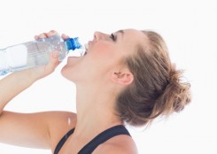 Woman drinking a bottle of water after workout